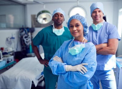 Portrait Of Multi-Cultural Surgical Team Standing In Hospital Operating Theater