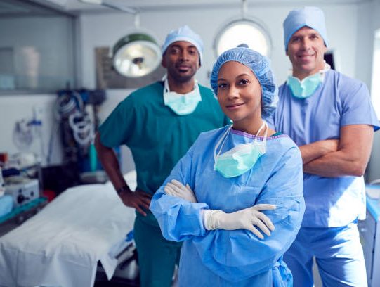 Portrait Of Multi-Cultural Surgical Team Standing In Hospital Operating Theater